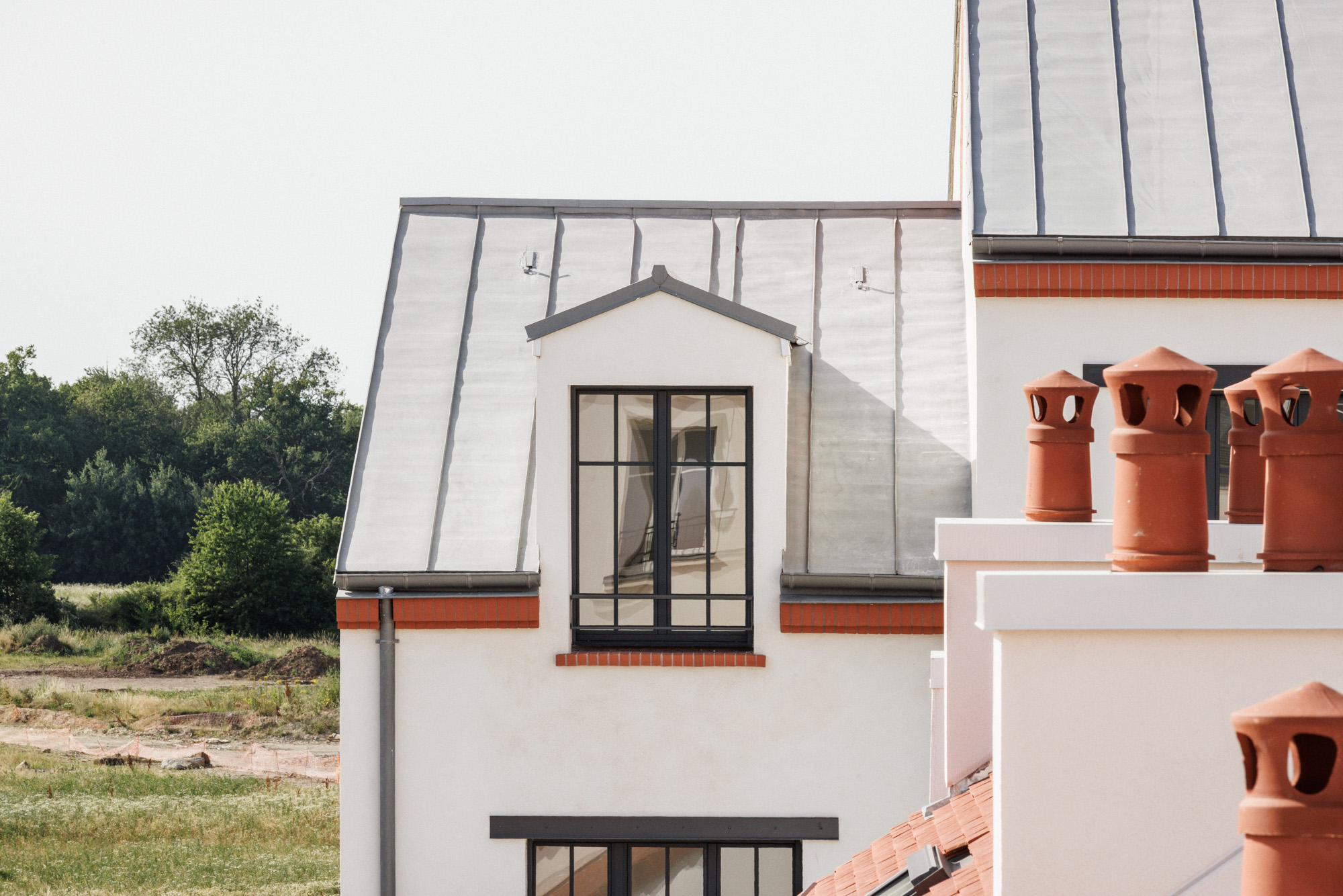 Détails de toitures, fenêtres et cheminées en séquençage sur la cour des artisans, projet de logement collectifs sociaux à Serris par Cussac Architectes et Associés (CA+A)